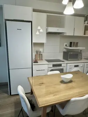 a kitchen with a wooden table and white cabinets at 214 Executive Suite, in Pretoria