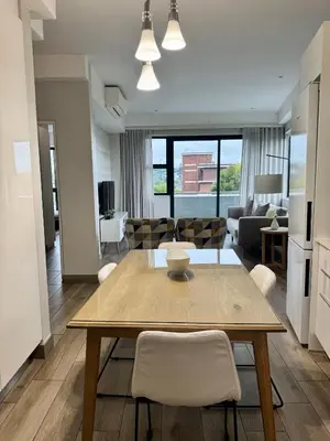 a dining room and living room with a table and chairs at 214 Executive Suite, in Pretoria