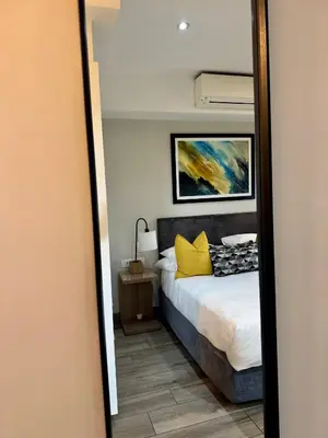 a bedroom with a bed and a mirror at 214 Executive Suite, in Pretoria