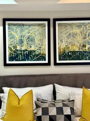 two framed art prints above a bed with yellow pillows at 214 Executive Suite, in Pretoria