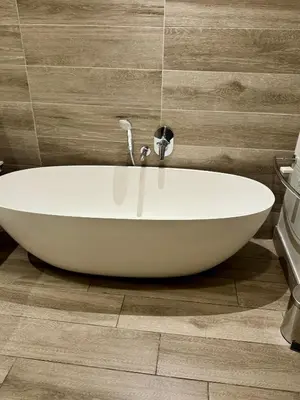a white bath tub sitting on a wooden floor in a bathroom at 214 Executive Suite, in Pretoria