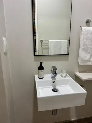 a white sink in a bathroom with a mirror at 214 Executive Suite, in Pretoria
