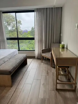a hotel room with a bed and a desk and a window at 214 Executive Suite, in Pretoria