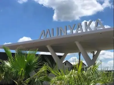 a sign for the entrance to a building with palm trees at Penflex in Midrand