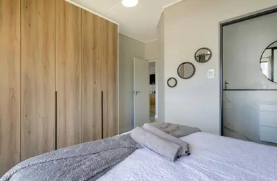 a bedroom with a bed and a large wooden cabinet at Penflex in Midrand