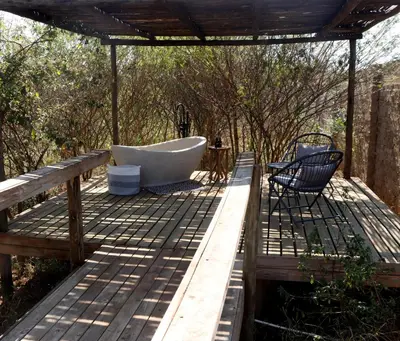 a deck with a tub and a chair on it at Makonde river lodge in Makonde