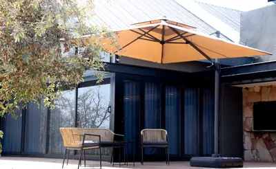a table and chairs under an umbrella on a patio at Makonde river lodge in Makonde