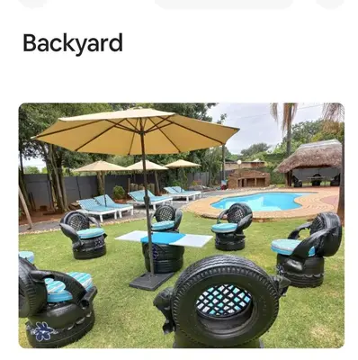 a group of chairs and an umbrella next to a pool at Amani Princely treat Silverton in Pretoria