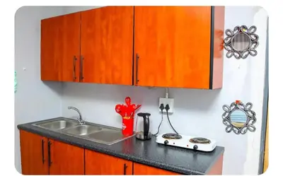 a kitchen counter with a sink and wooden cabinets at Amani Princely treat Silverton in Pretoria