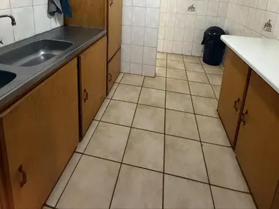 a kitchen with a sink and a tiled floor at Bushveld Inn Guest House in Mokopane