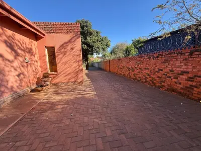 a brick sidewalk next to a brick wall at Bushveld Inn Guest House in Mokopane