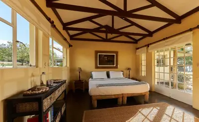 a bedroom with a large bed and windows at Geelhoutkop Farm