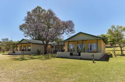a house with a tree in front of it at Geelhoutkop Farm