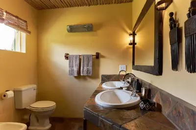 a bathroom with two sinks and a toilet at Geelhoutkop Farm