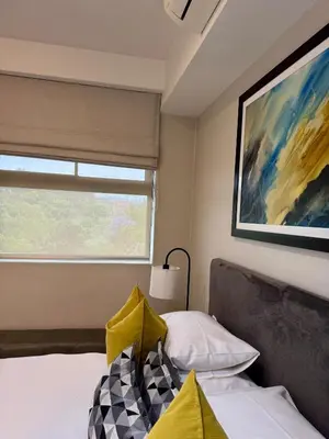 a bedroom with a bed and a painting on the wall at 2 beds, 2 bedrooms Family Suites 214 & 214-1 in Pretoria