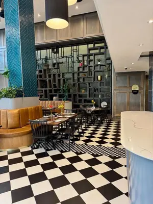 a restaurant with tables and chairs on a checkered floor at 2 beds, 2 bedrooms Family Suites 214 & 214-1 in Pretoria