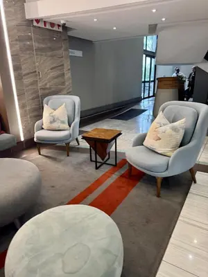 a living room with two chairs and a table at 2 beds, 2 bedrooms Family Suites 214 & 214-1 in Pretoria