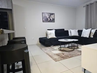 a living room with a black couch and a table at Eland Ridge in Boksburg
