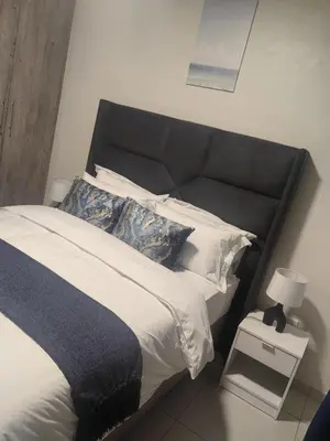 a bedroom with a bed with a black headboard and pillows at Eland Ridge in Boksburg