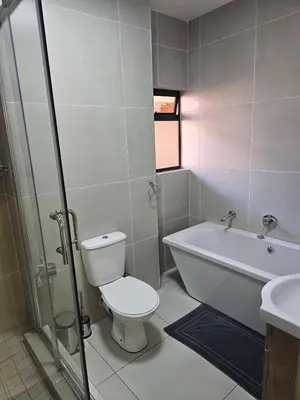a bathroom with a toilet and a tub and a sink at Eland Ridge in Boksburg