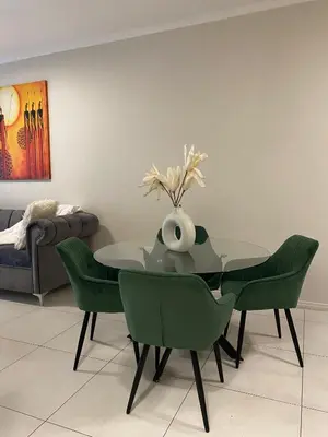 a dining room with a table and green chairs at Elegant & Timeless at 93 on new in Midrand