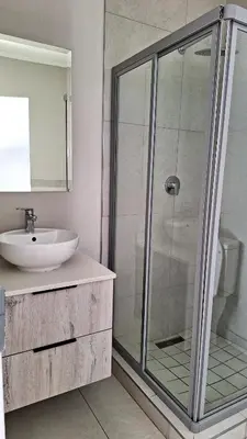 a bathroom with a glass shower and a sink at Elegant & Timeless at 93 on new in Midrand