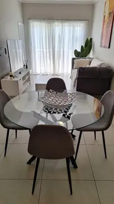 a living room with a glass table and chairs at Elegant & Timeless at 93 on new in Midrand