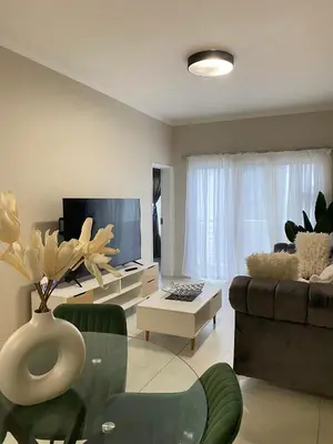 a living room with a couch and a tv at Elegant & Timeless at 93 on new in Midrand