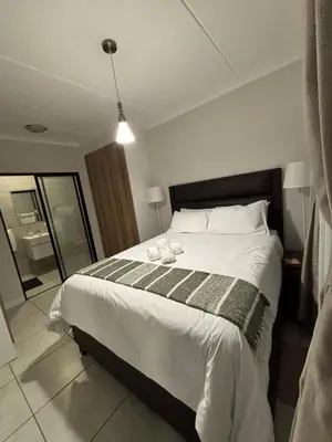 a bedroom with a large bed and a mirror at Aqua Haven-The Blyde in Pretoria