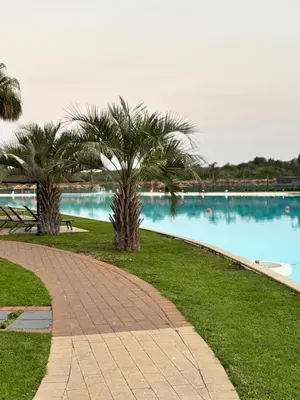 a walkway with palm trees next to a body of water at Aqua Haven-The Blyde in Pretoria