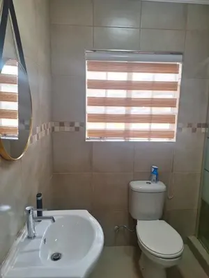 a bathroom with a toilet and a sink and a mirror at 310 Bonnyvale in Kempton Park
