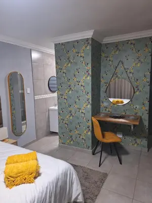a bedroom with a bed and a desk and a mirror at 310 Bonnyvale in Kempton Park