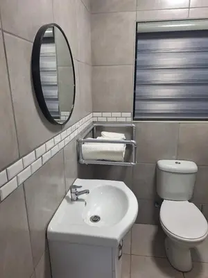 a bathroom with a sink and a toilet and a mirror at 310 Bonnyvale in Kempton Park