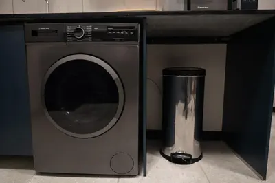 a washing machine with a trash can next to it at The Precinct Luxury Apartment - Waterfall in Kyalami