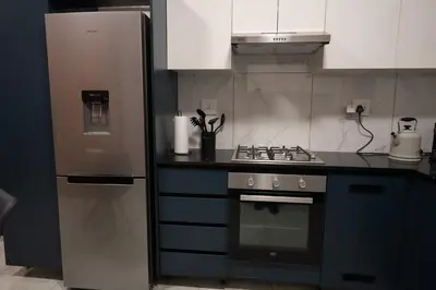 a kitchen with a refrigerator and a stove at The Precinct Luxury Apartment - Waterfall in Kyalami