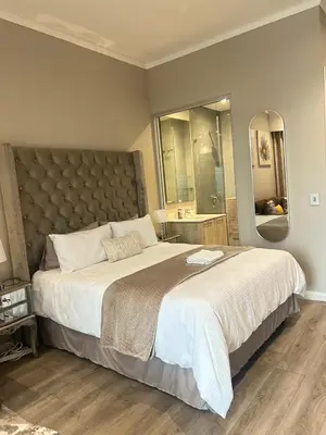 a bedroom with a large bed and a large mirror at Menlyn Maine 1413 in Pretoria