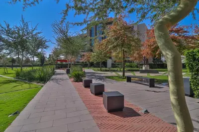 a park with benches and trees and a building at Menlyn Maine 1413 in Pretoria