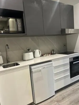 a kitchen with white cabinets and a sink and a microwave at Menlyn Maine 1413 in Pretoria