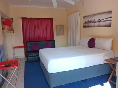 a hotel room with a bed and a chair at Yana House in Polokwane