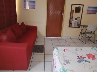 a living room with a red couch and a table at Yana House in Polokwane