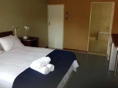 a hotel room with a bed with towels on it at Amigos Bed & Breakfast - No loadshedding in Nelspruit