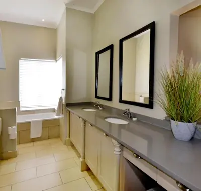 a bathroom with two sinks and two mirrors at Elegant 4 ppl Villa nested in a picturesque town