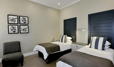 a hotel room with two beds and a chair at Elegant 4 ppl Villa nested in a picturesque town