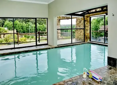 an empty swimming pool with windows and blue water at Elegant 4 ppl Villa nested in a picturesque town