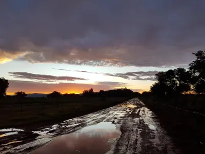 a muddy road with a sunset in the background at Oryx Lodge in Brits
