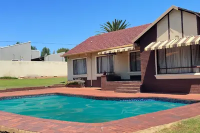a house with a swimming pool in front of it at Inconova fly in Kempton Park