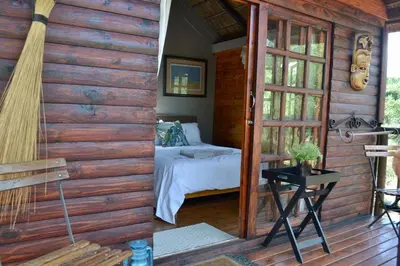 a bedroom in a log cabin with a bed at Kudusdrift Farmstay in Vaalwater
