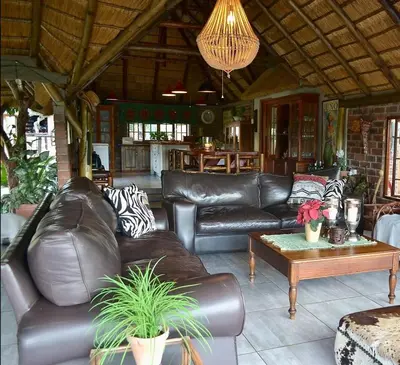 a living room with leather couches and a table at Kudusdrift Farmstay in Vaalwater