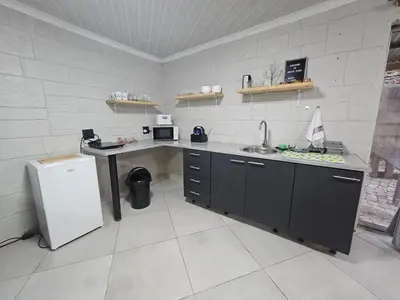 a kitchen with a sink and a refrigerator at Sally's Place in Boksburg
