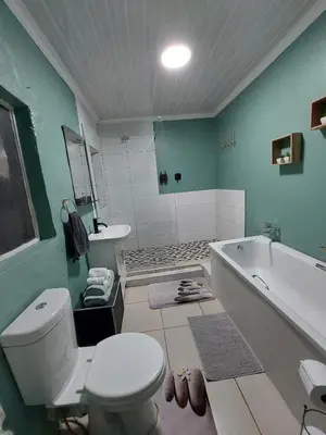 a bathroom with a toilet and a tub and a sink at Sally's Place in Boksburg